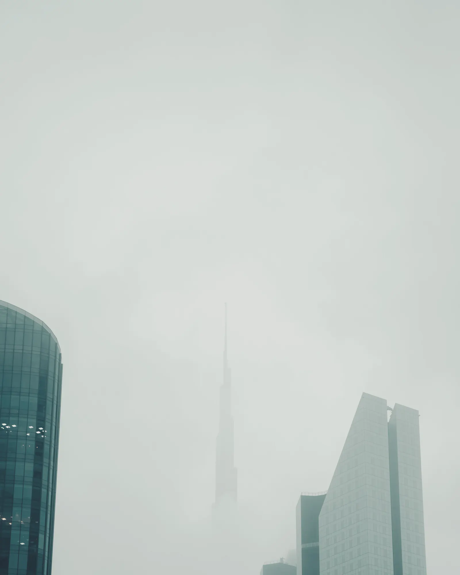 Burj Khalifa and Downtown Dubai towers rising through fog